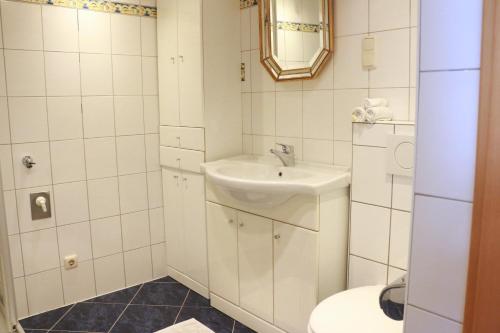 a bathroom with a sink and a toilet at Ferienwohnung am Bio-Bauernhof in Obertrum am See