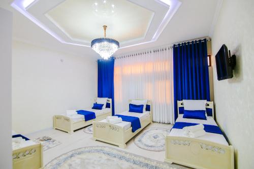 a bedroom with three beds and a chandelier at Cozy Two-Storey House in Bukhara