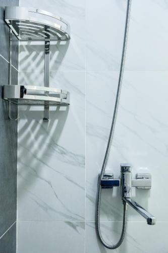a shower in a bathroom with a hose at Cozy Two-Storey House in Bukhara