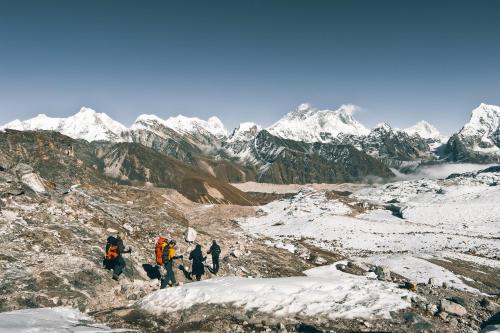 um grupo de pessoas andando em uma montanha de neve em Mountain Lodges of Nepal - Namche em Namche