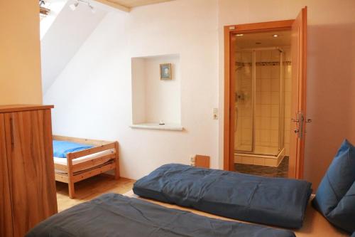 um quarto com 2 camas e uma casa de banho com um chuveiro em Ferienwohnung am Bio-Bauernhof em Obertrum am See