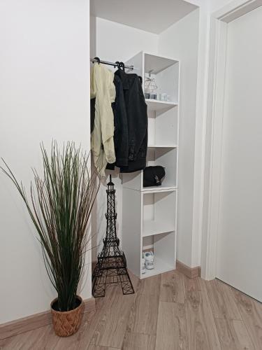 una habitación con un estante con una bolsa y la torre Eiffel en Studio totalement meublé L'ethnique, 