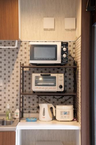 a microwave sitting on top of a kitchen at Guest House Goettingen in Kyoto