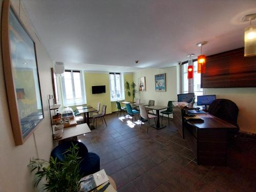 a living room with a couch and tables and chairs at Hotel Le Mistral in Cannes