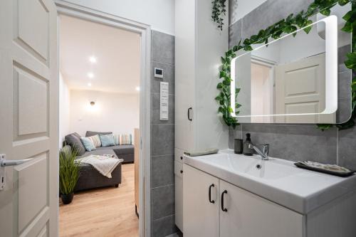 布達佩斯的住宿－Mira Holiday Apartment，一间带水槽和镜子的浴室和一间客厅