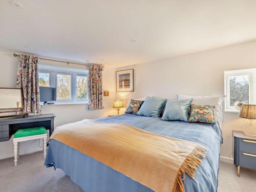 a bedroom with a large bed with blue sheets at 1 Bed in Crewkerne 94097 in Mosterton