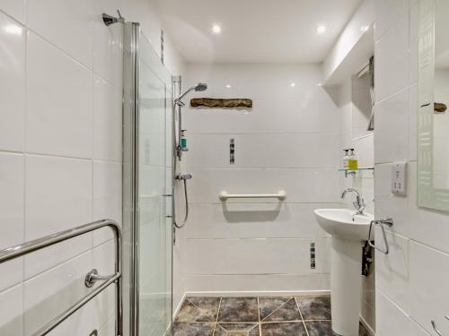 a white bathroom with a shower and a sink at 1 Bed in Hawes 94120 in Hawes