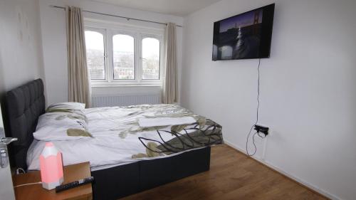 sypialnia z łóżkiem i telewizorem na ścianie w obiekcie 3BED Maisonette Near CityCentre w Birmingham