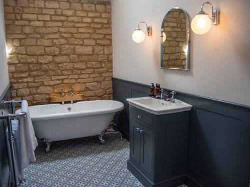 een badkamer met een bad en een wastafel bij 1 Bed in Kirkby Green 94133 