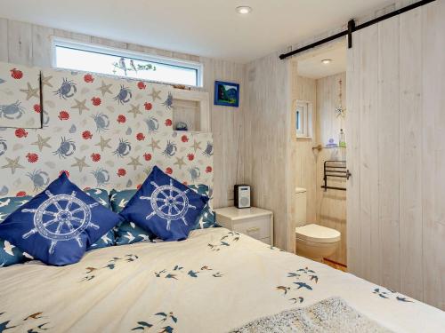 a bedroom with a bed with blue pillows at 1 Bed in Bridport 94154 in Chideock