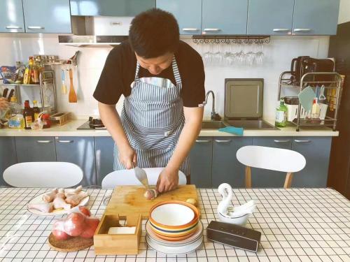 a woman in a kitchen preparing food on a cutting board at CSDY House in Shanghai