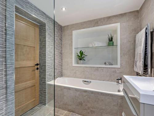 a bathroom with a bath tub and a sink at 1 Bed in Woolacombe 93920 in Woolacombe