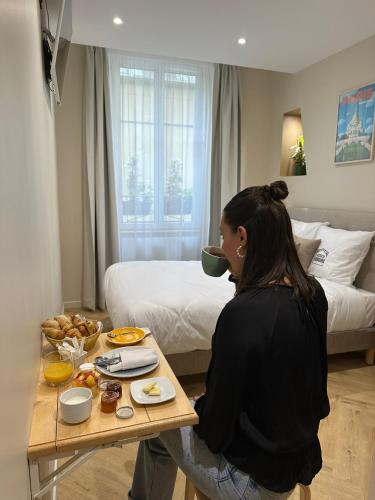 une femme assise à une table avec un bol de nourriture dans l'établissement Les Chambres du Faubourg, à Paris