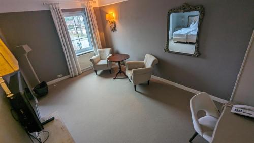 a room with a mirror and a table and chairs at Schloss Krugsdorf Golf & Hotel in Krugsdorf