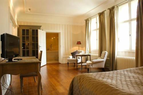 a bedroom with a bed and a desk with a television at Schloss Krugsdorf Golf & Hotel in Krugsdorf