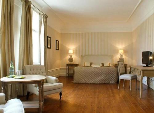 a bedroom with a bed and a table and chairs at Schloss Krugsdorf Golf & Hotel in Krugsdorf