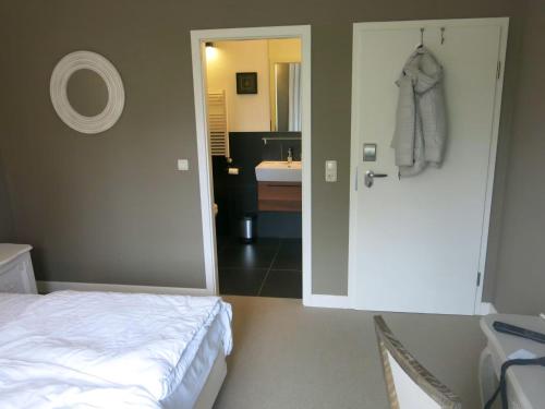 a bedroom with a bed and a bathroom with a sink at Schloss Krugsdorf Golf & Hotel in Krugsdorf