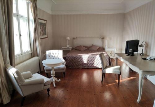 a bedroom with a bed and a desk and chairs at Schloss Krugsdorf Golf & Hotel in Krugsdorf