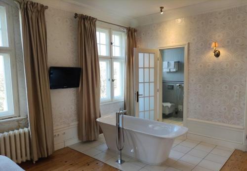 a bathroom with a large tub in a room at Schloss Krugsdorf Golf & Hotel in Krugsdorf