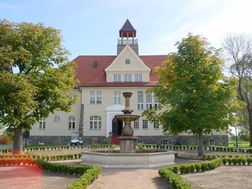 a building with a fountain in front of it at Schloss Krugsdorf Golf & Hotel in Krugsdorf