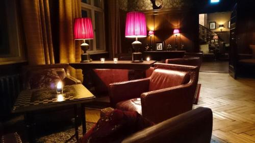 a lobby with chairs and tables and two lamps at Schloss Krugsdorf Golf & Hotel in Krugsdorf