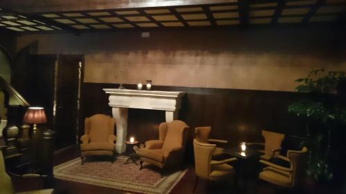 a living room with a fireplace and chairs and a table at Schloss Krugsdorf Golf & Hotel in Krugsdorf