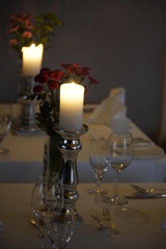 a table with candles and wine glasses on a table at Schloss Krugsdorf Golf & Hotel in Krugsdorf