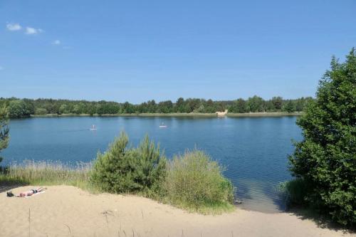 a person laying on a beach next to a lake at Schloss Krugsdorf Golf & Hotel in Krugsdorf