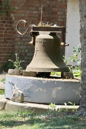 an old bell sitting next to a brick building at Schloss Krugsdorf Golf & Hotel in Krugsdorf