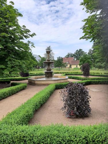 a fountain in the middle of a garden at Schloss Krugsdorf Golf & Hotel in Krugsdorf