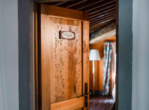 a wooden door in a room with a bed at Rifugium in Greve in Chianti