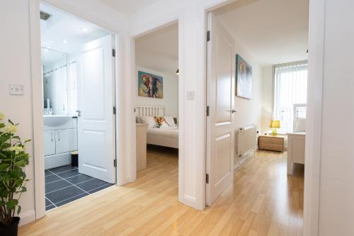 a white room with a bed and a bathroom at Withington Apartments- Wilmslow Road- Free Parking in Manchester
