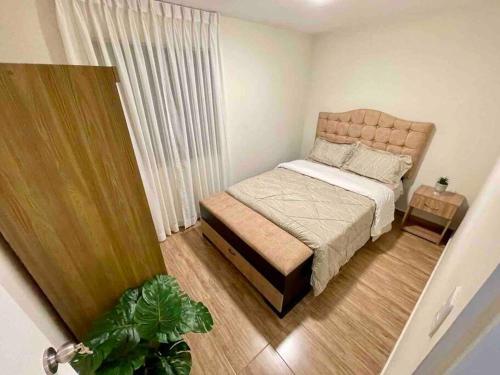 Habitación pequeña con cama y planta en 204 Exclusivo Departamento III con estacionamiento, en Cajamarca