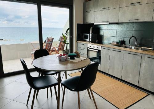 a kitchen with a table and chairs and the ocean at zonapartments A sea view-city center in Chania