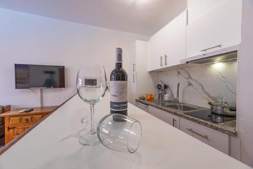 a bottle of wine and two wine glasses on a counter at Aptos. Comte D´Empuries in Empuriabrava