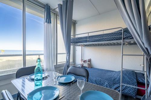 Cette chambre dispose d'une table à manger et de lits superposés. dans l'établissement Appartement à La grande plage, au Barcarès