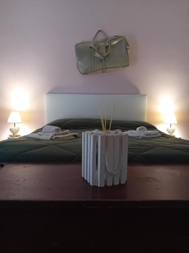 a bed with a table with a bag on top of it at Garda City Home Family Apartments in Garda