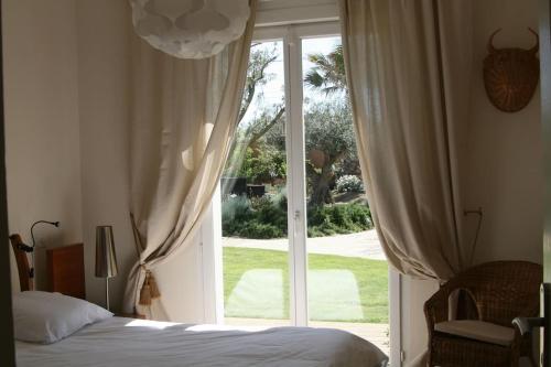 1 dormitorio con cama y ventana grande en la villa d'Ariane-piscine-jaccuzi-15 mn Mer, en Vendargues