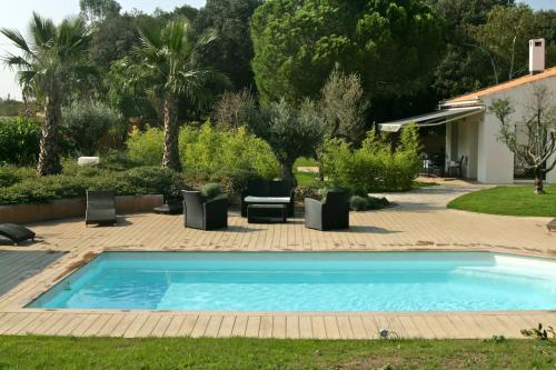 une piscine dans une cour avec un patio dans l'établissement la villa d'Ariane-piscine-jaccuzi-15 mn Mer, à Vendargues