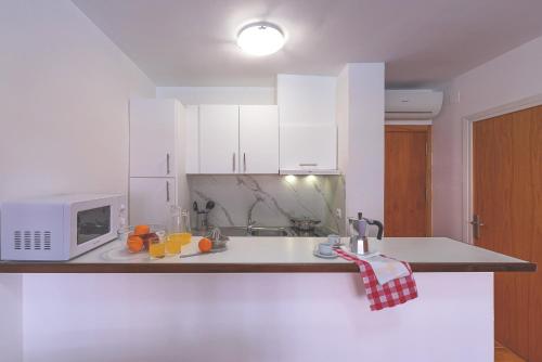 a kitchen with a sink and a microwave at Aptos. Comte D´Empuries in Empuriabrava