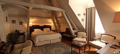 um quarto com uma cama e duas cadeiras num quarto em Le Clos Sainte-Marie em Mesland