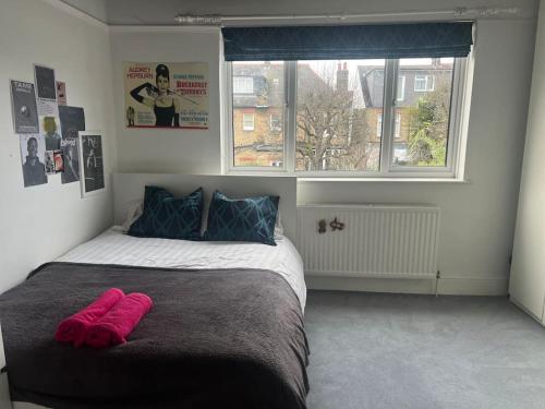 - une chambre avec un lit et une serviette rose dans l'établissement Luxury 4 bedroom house in London featured on TV, à Londres