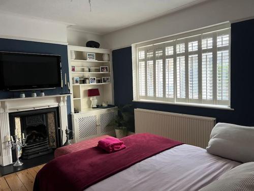 - une chambre avec un lit, une cheminée et une télévision dans l'établissement Luxury 4 bedroom house in London featured on TV, à Londres