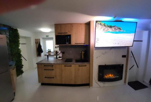 a kitchen with a fireplace and a tv on the wall at Adriatic SPA Apartment in Selce