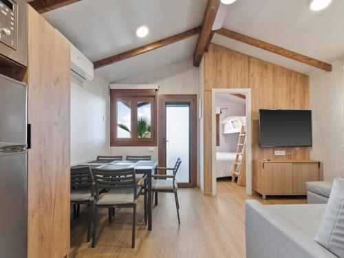 a dining room with a table and chairs and a bedroom at Devesa Gardens in El Saler