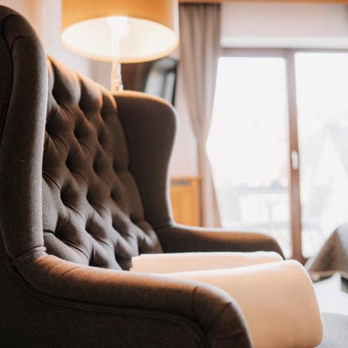ein Wohnzimmer mit einem Stuhl und einer Lampe in der Unterkunft Hotel-Restaurant Peifer in Brodenbach