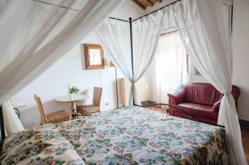 a bedroom with a bed and a chair and a window at Rifugium in Greve in Chianti
