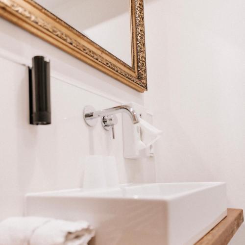 La salle de bains est pourvue d'un lavabo et d'un miroir. dans l'établissement Hotel-Restaurant Peifer, à Brodenbach