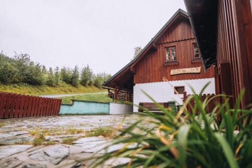 a wooden house with a stone path next to a building at Chata Říp in Rokytnice nad Jizerou