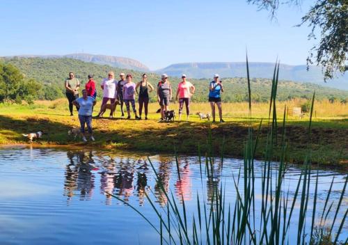 a group of people standing next to a body of water at Imbabali Retreat & Venue in Magaliesburg
